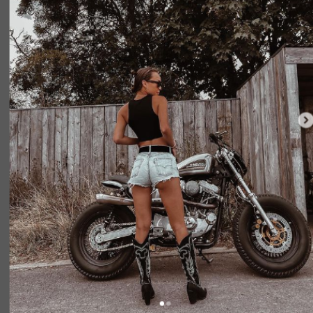 Naomi J. Ogawa strikes a pose alongside her trusty two-wheeler in an alluring photoshoot capturing the essence of her biking spirit.
